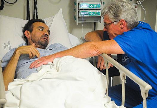 Dr. Chris Flynn listens to Alonso Camarena talk about the pain he’s experiencing during a recent visit to the Santa Barbara Cottage Hospital emergency room. Camarena, who does not have insurance, discovered he had cancer on his first visit to an emergency room two years ago. (Lara Cooper / Noozhawk photo)