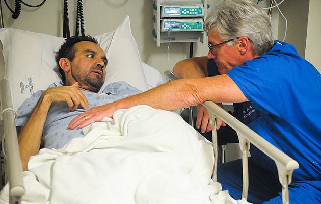 Dr. Chris Flynn listens to Alonso Camarena talk about the pain he’s experiencing during a recent visit to the Santa Barbara Cottage Hospital emergency room. Camarena, who does not have insurance, discovered he had cancer on his first visit to an emergency room two years ago. (Lara Cooper / Noozhawk photo)