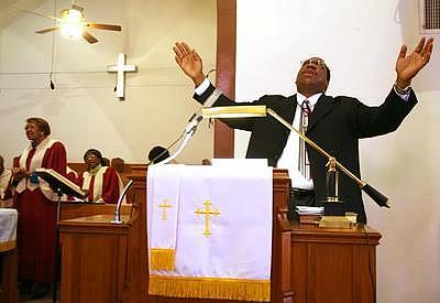 The Rev. Jeffrey M. Parker prays during a service at Community Reformed Church in the Sobrante Park neighborhood.