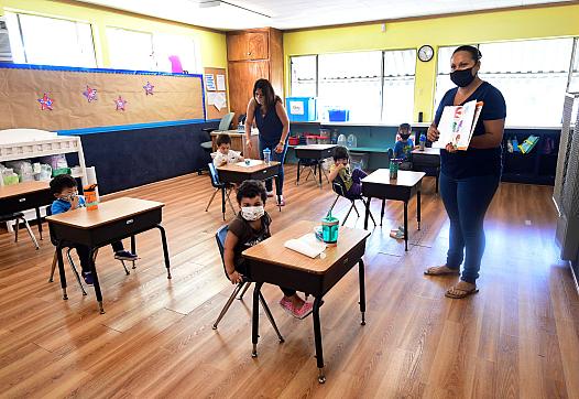 Masked teachers at a school teaching