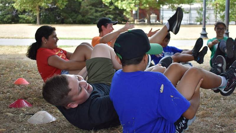 Kids practice group exercise at East Boston's Memorial Park as part of the health program Let's Go Movin'.