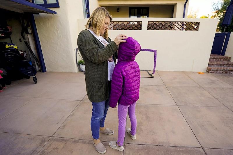 Amanda Buzzell ajusta el pelo de su hija antes de salir a dar un paseo en bici.