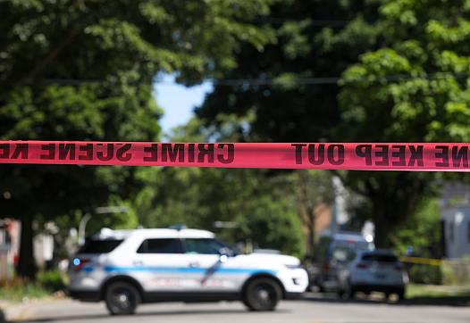 Police tape marks off a Chicago street as officers investigate the scene of a fatal shooting in the city's South Side on Tuesday