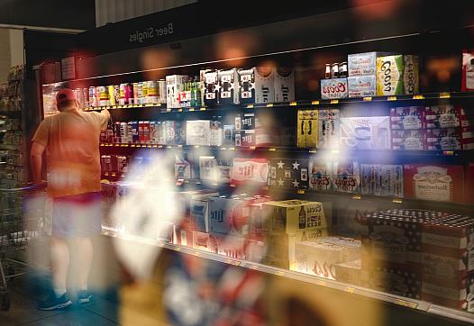 ALBUQUERQUE, NEW MEXICO – JUNE 26, 2022: A man shops in the alcohol department at a grocery store in Albuquerque.