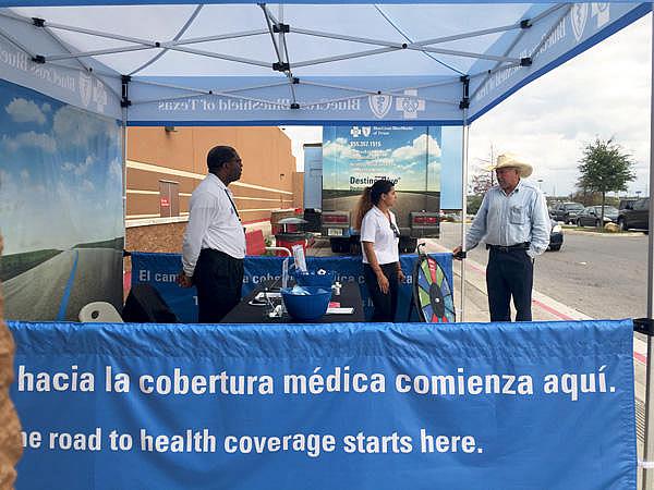 Insurance agents working with Blue Cross Blue Shield of Texas answered questions outside of a Target in San Antonio. (Veronica Zaragovia/KUT)