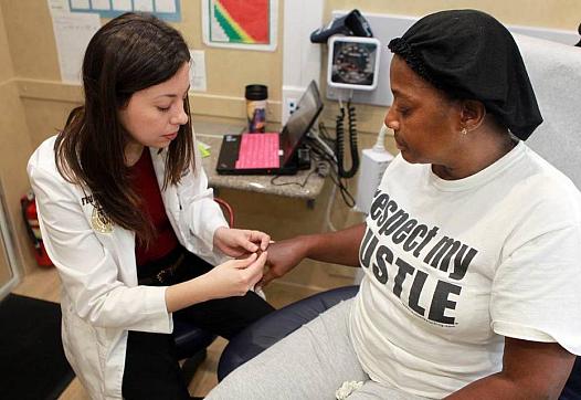 Dr. Annelys Hernandez, left, checks out Cynthia Louis in Florida International University’s Mobile Health Center. (Peter Andrew Bosch/Miami Herald staff)