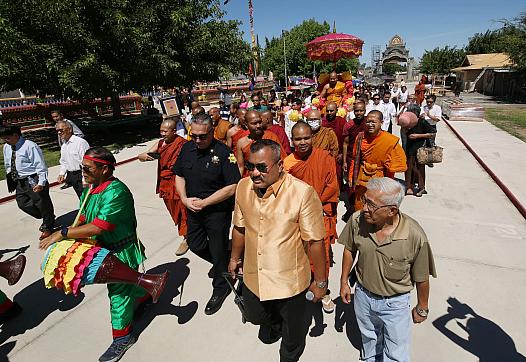 Danny Kim walks a parade for the Temple Abbot, Say Bunthon during the Holy Water Blessing ceremony at the Fresno Cambodian Buddh