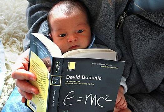 Infant reads a science book. E=mc2