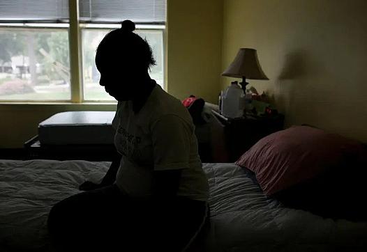 Woman sitting on her bed in a room