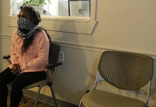 A woman sits in a waiting room.