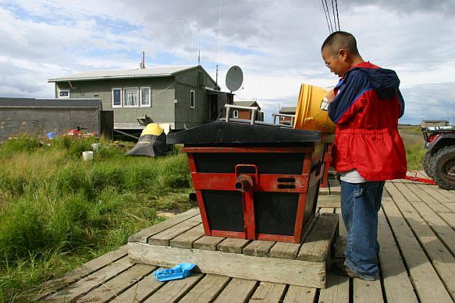 In some villages, the only option for human waste is to use “honeybuckets,” a bucket fitted with a toilet seat. It’s the chore of children to empty them.