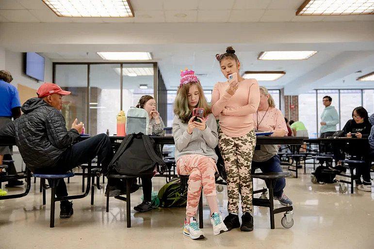 Leah Gonzalez, right, 16, one of Loryann's best friends, calls her parents to have a small birthday party for Loryann. Loryann, left, said she already made three best friends at the new school. YEHYUN KIM / CTMIRROR.ORG