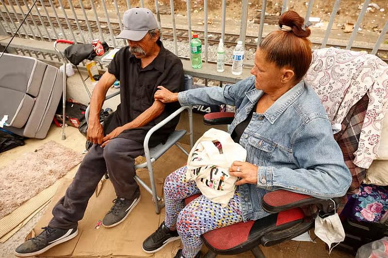 Denise Lerma comforts Paul Carrera after they received the COVID vaccine shots. Credit: Al Seib/Los Angeles Times/Getty Images.