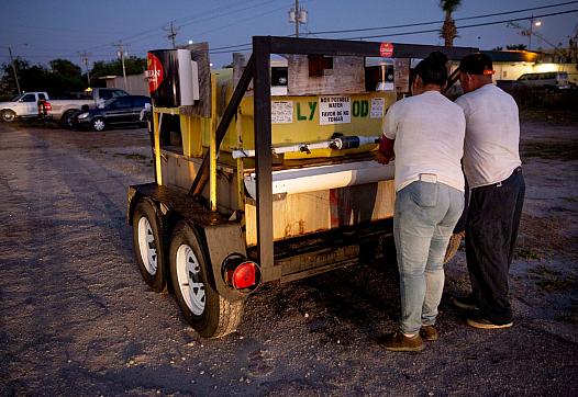 Norma Caldon, left, and Inocente Ordoñez, right, wash their hands before getting on a bus to work in Immokalee on Friday, April 