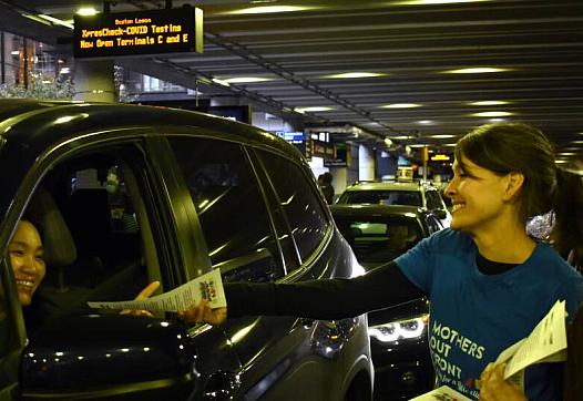 Sonja Tengblad hands an information sheet to a driver idling outside of Logan Airport’s Terminal B.