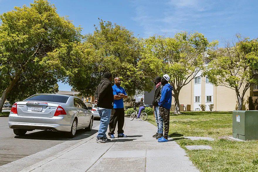 4 people talking on sidewalk