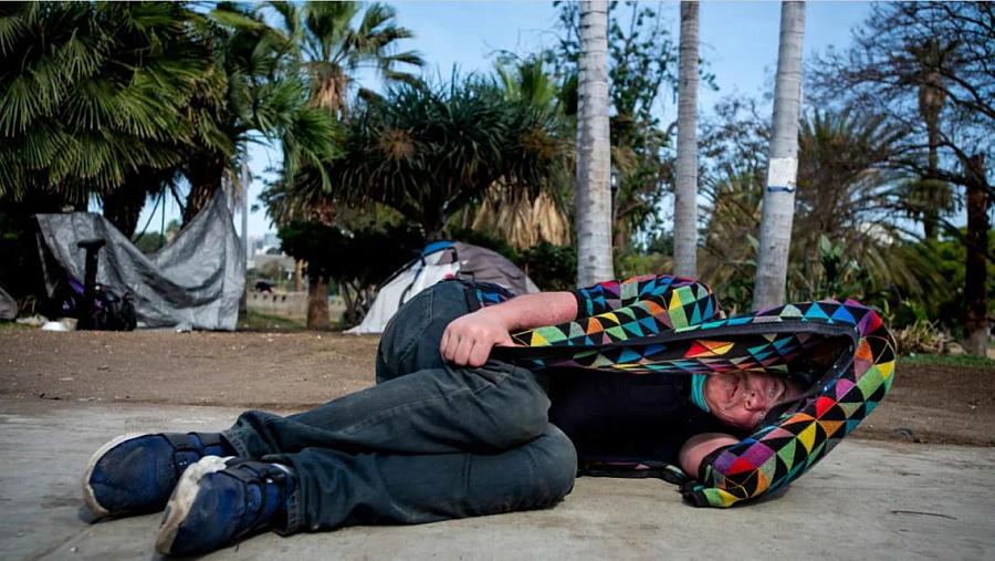 A person sleeping on sidewalk