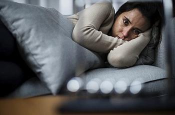 Person lying on the bed looking at camera