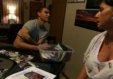 Kris Dasch and son Kameron Edmonds, 19, look at photos of her younger son and his brother, Kavon Cooper. Jamie Smith Hopkins/The Center for Public Integrity