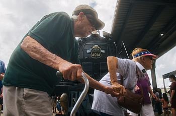 An old couple walking in a crowded space