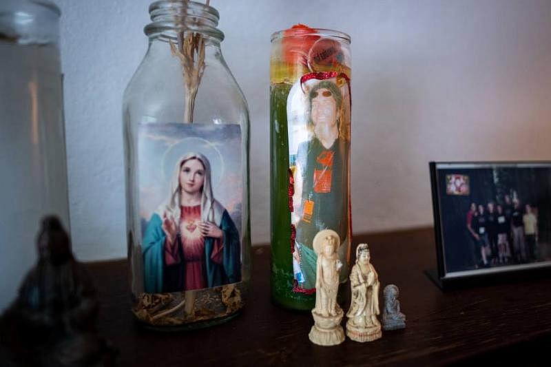 An altar includes a candle from a memorial for Pete Morse on the mantel of Rachel McLean's home on March 10, 2022. (Beth LaBerge/KQED)