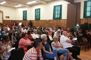 En salón de la Iglesia Resurrección. Residentes afectados por la contaminación de plomo escuchan cómo va la limpieza de su barri