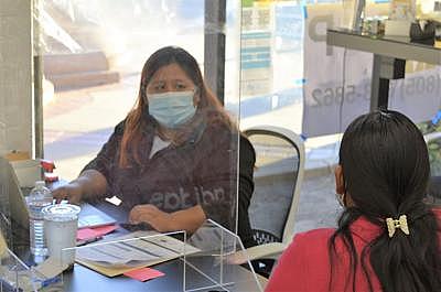 Francisca Camarillo, a staff member in the Santa Maria office of Mixteco Indigena Community Organizing Project (MICOP), speaks with a client about the impacts of COVID-19 and possible assistance options in February. MICOP is one of many organizations in the county working to expand access to COVID-19 vaccines in Santa Barbara County.   Laura Place, Staff