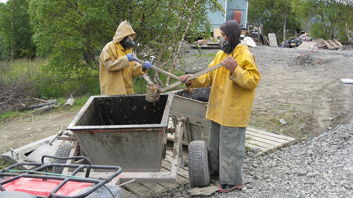 A 2011 photo shows residents of Pitkas Point, Alaska wearing breathing apparatus to transfer human waste to a collection bucket,