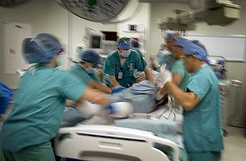 Medical workers transfer patient to surgical table . 